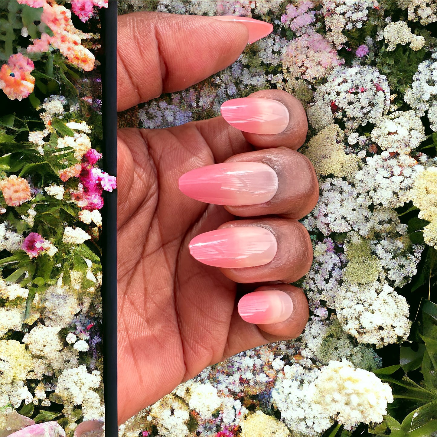 Hand featuring pink ombre almond-shaped press-on nails against white flowered background