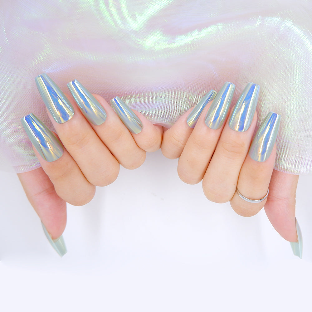 Fingers adorned in long coffin shaped      press on nails, in a blue chrome color, holding a white fabric.