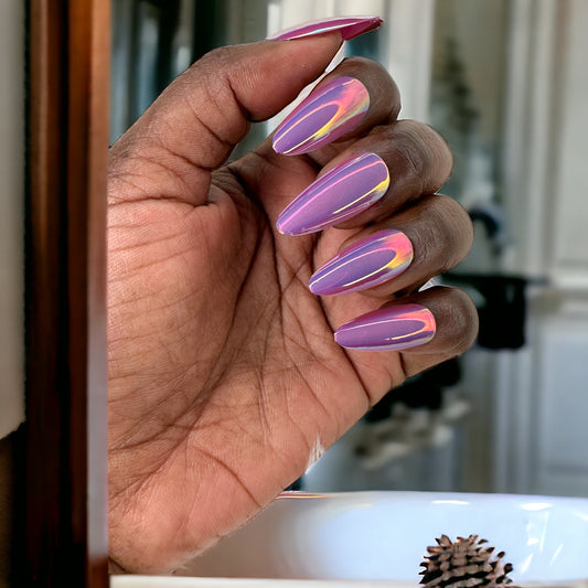 Hand with fingers showcasing medium almond-shaped press-on nails in pink chrome color against a neutral background