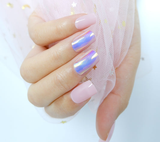 Close-up of short of a hand with square-shaped pink chrome  press-on nails gripping a white mesh fabric against a plain white backdrop